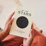 By The Stars book in hands